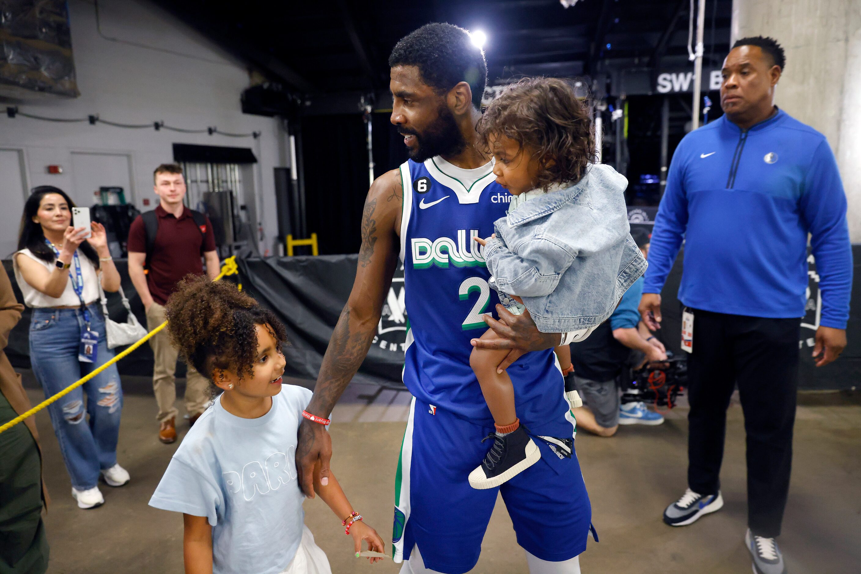 Dallas Mavericks guard Kyrie Irving (2) brings part of his family to the locker room...