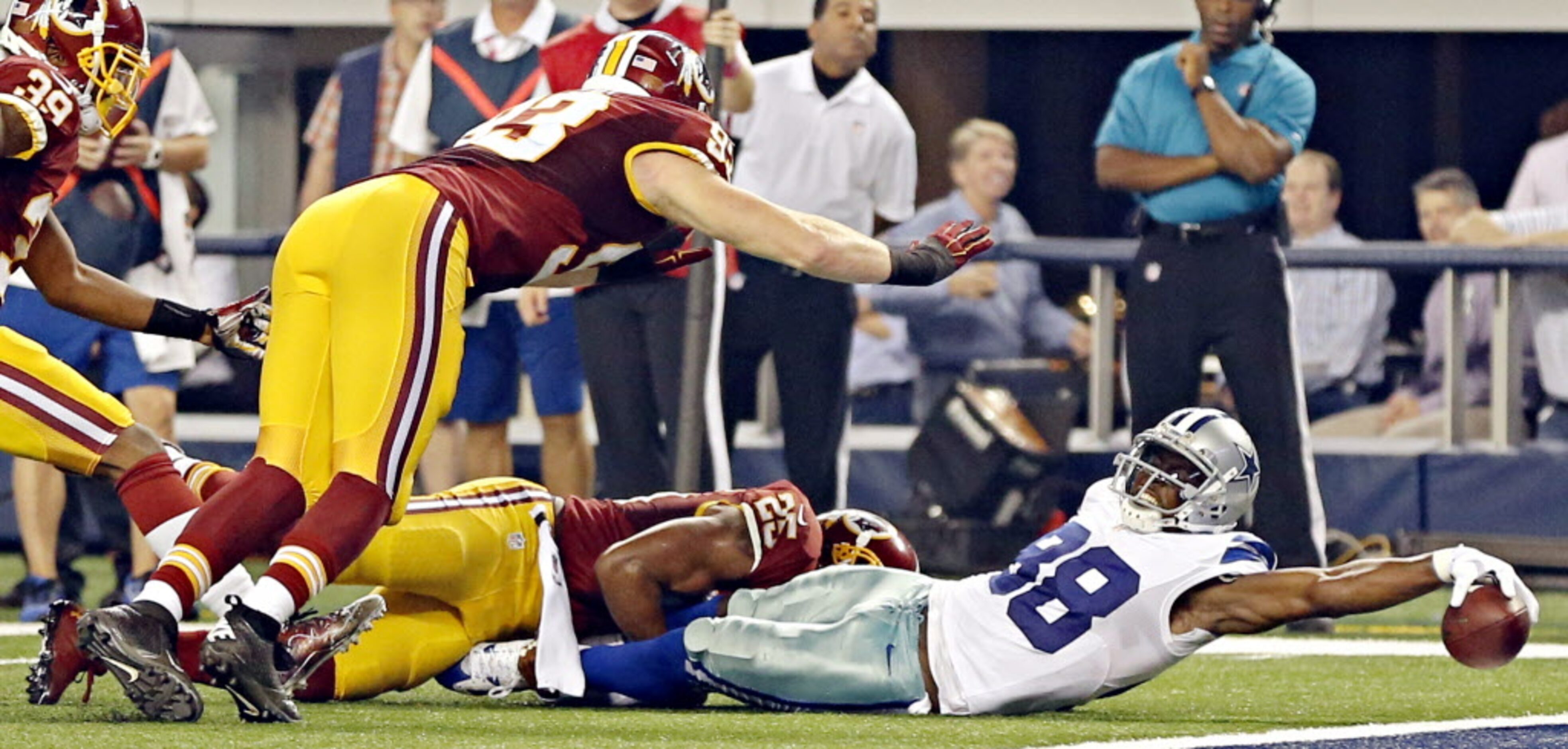 Dallas Cowboys wide receiver Dez Bryant (88) stretches away from a tackle by Washington...