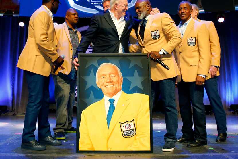 Dallas Cowboys owner Jerry Jones (center) gives a big hug to Emmitt Smith after a painted...