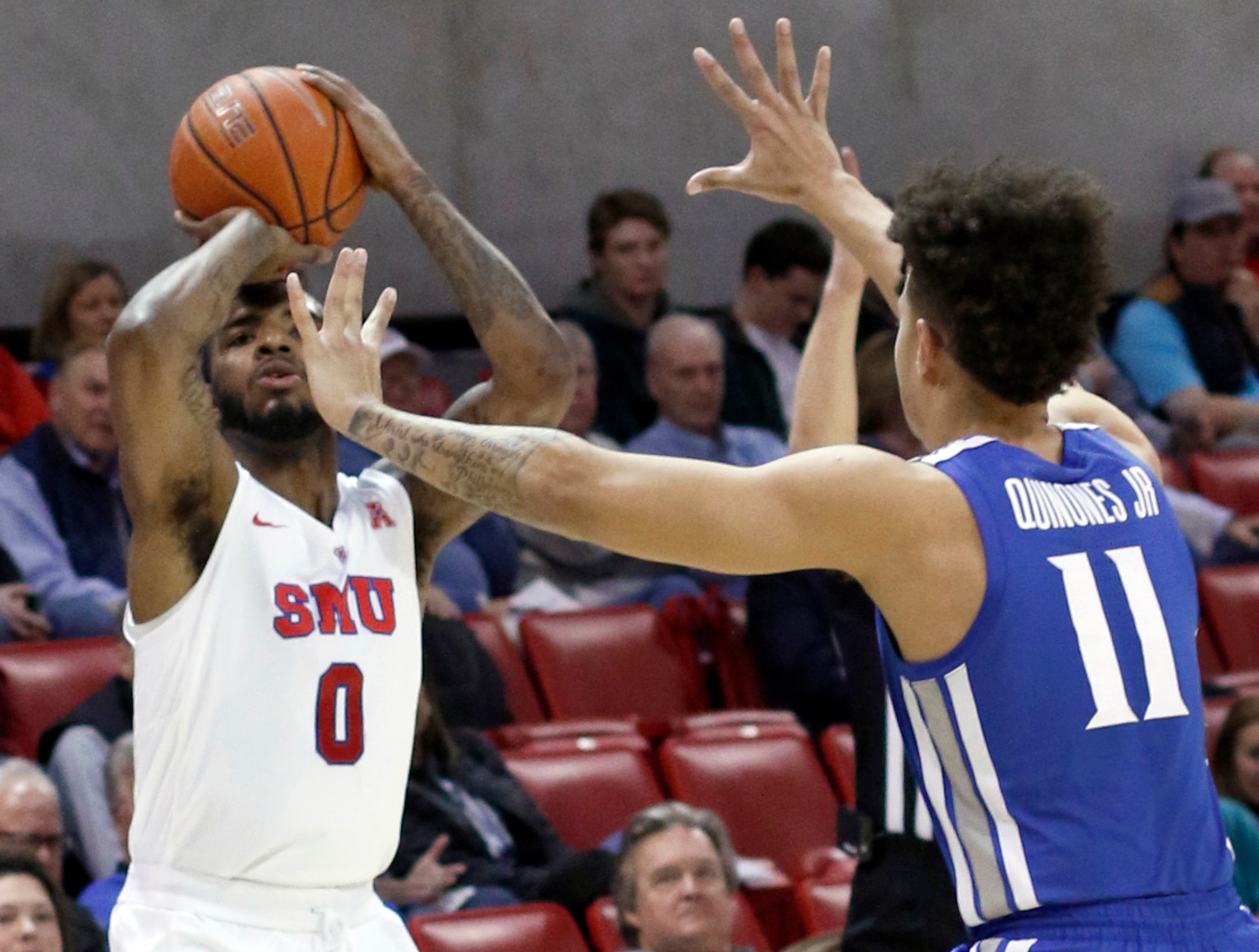 SMU guard Tyson Jolly (0) gets off a long range 3-pointer despite the defensive effort of...