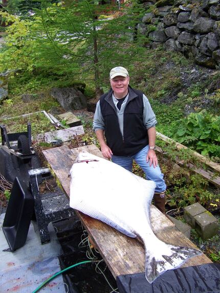 Edward Burns stands next to a 165-pound halibut that took a half-hour to reel. (Courtesy of...