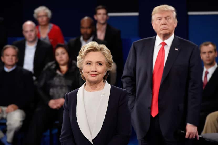 Hillary Clinton and and Donald Trump listen during the town hall debate at Washington...