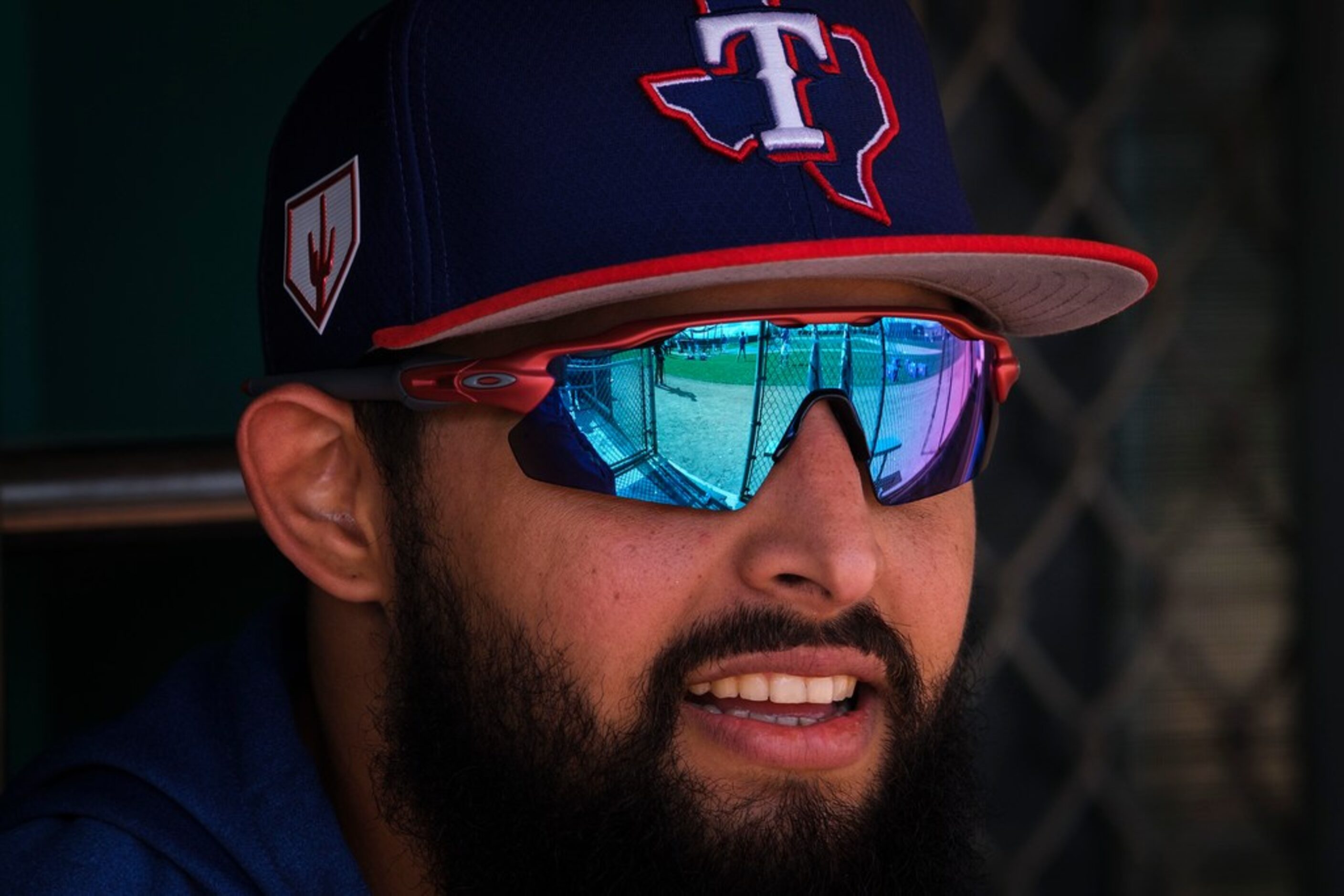 Texas Rangers infielder Rougned Odor watches from a dugout as teammates take batting...