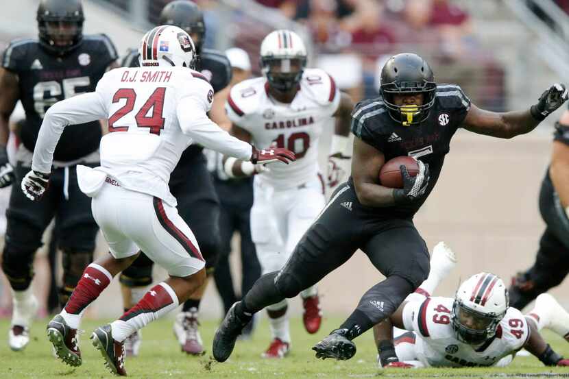 Texas A&M Aggies running back Tra Carson (5) attempts to evade South Carolina Gamecocks...