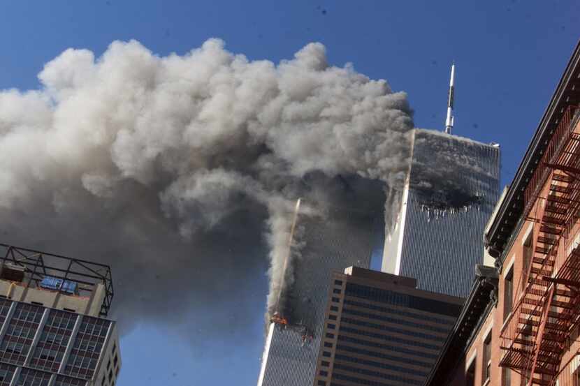 Smoke rises from the burning twin towers of the World Trade Center after terrorists hijacked...
