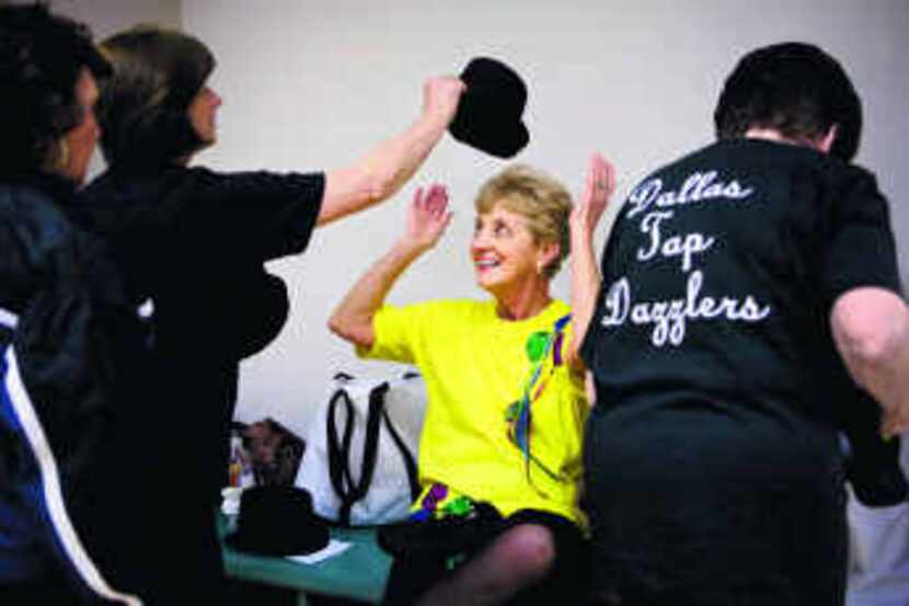  Dee Olson grabs Sandy McCravy's top hat after rehearsing with the Dallas Tap Dazzlers at...