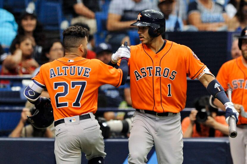 Houston Astros' Carlos Correa (1) congratulates Jose Altuve (27) after Altuve's solo home...