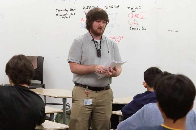 Bradley Grissom, 24, an AP World History teacher at Plano East High School, passes out an...
