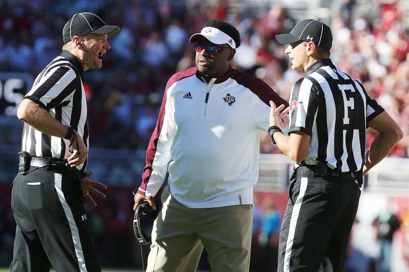 Texas A&M head coach Kevin Sumlin, center, talks to referees following a call against the...
