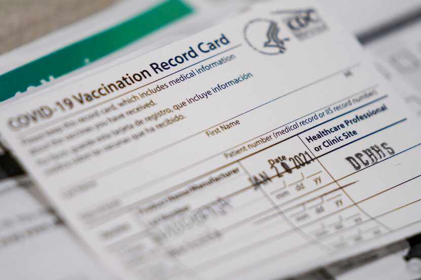 A vaccination record cards sit ready at a station at the Dallas County  COVID-19...