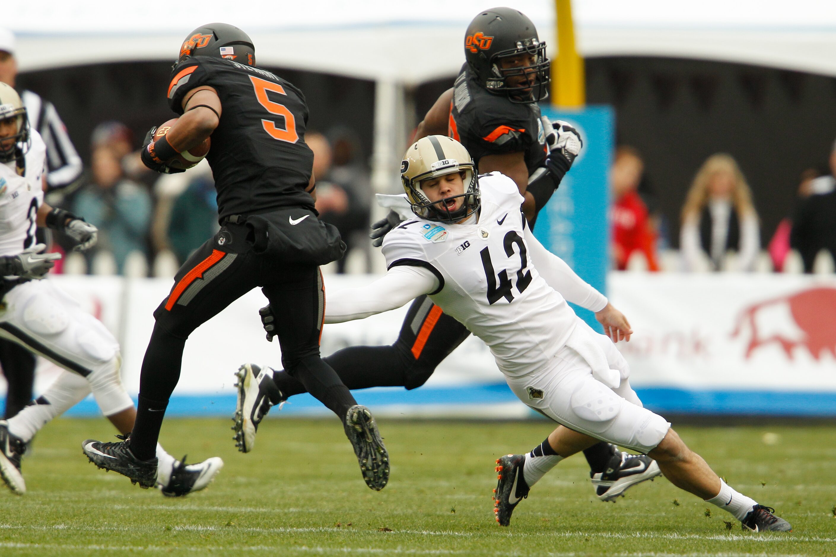 Purdue's Andy James Garcia (42) attempts to tackle Oklahoma State's Josh Stewart (5) during...