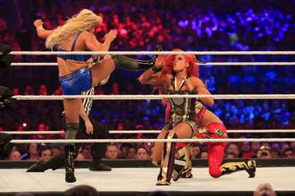 Charlotte, left, wrestles Becky Lynch, center, and Sasha Banks during WrestleMania 32 at...