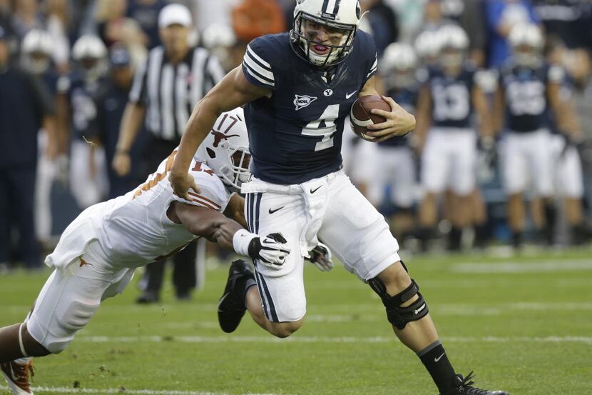 BYU quarterback Taysom Hill runs through a Texas tackle during the Cougars 40-21 victory...