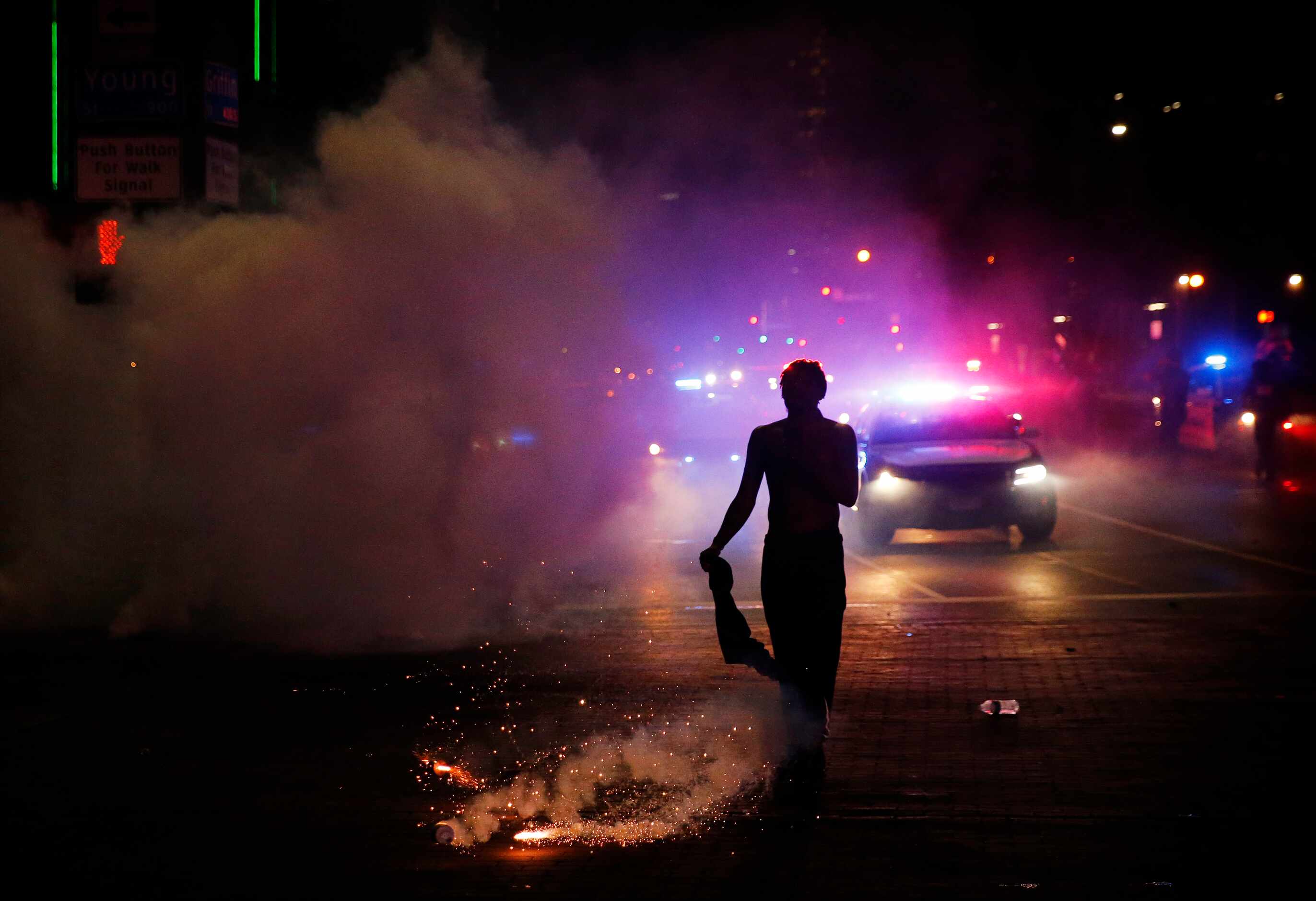A protestor is nearly hit by a tear gas canister at the intersection of Young St. and S....