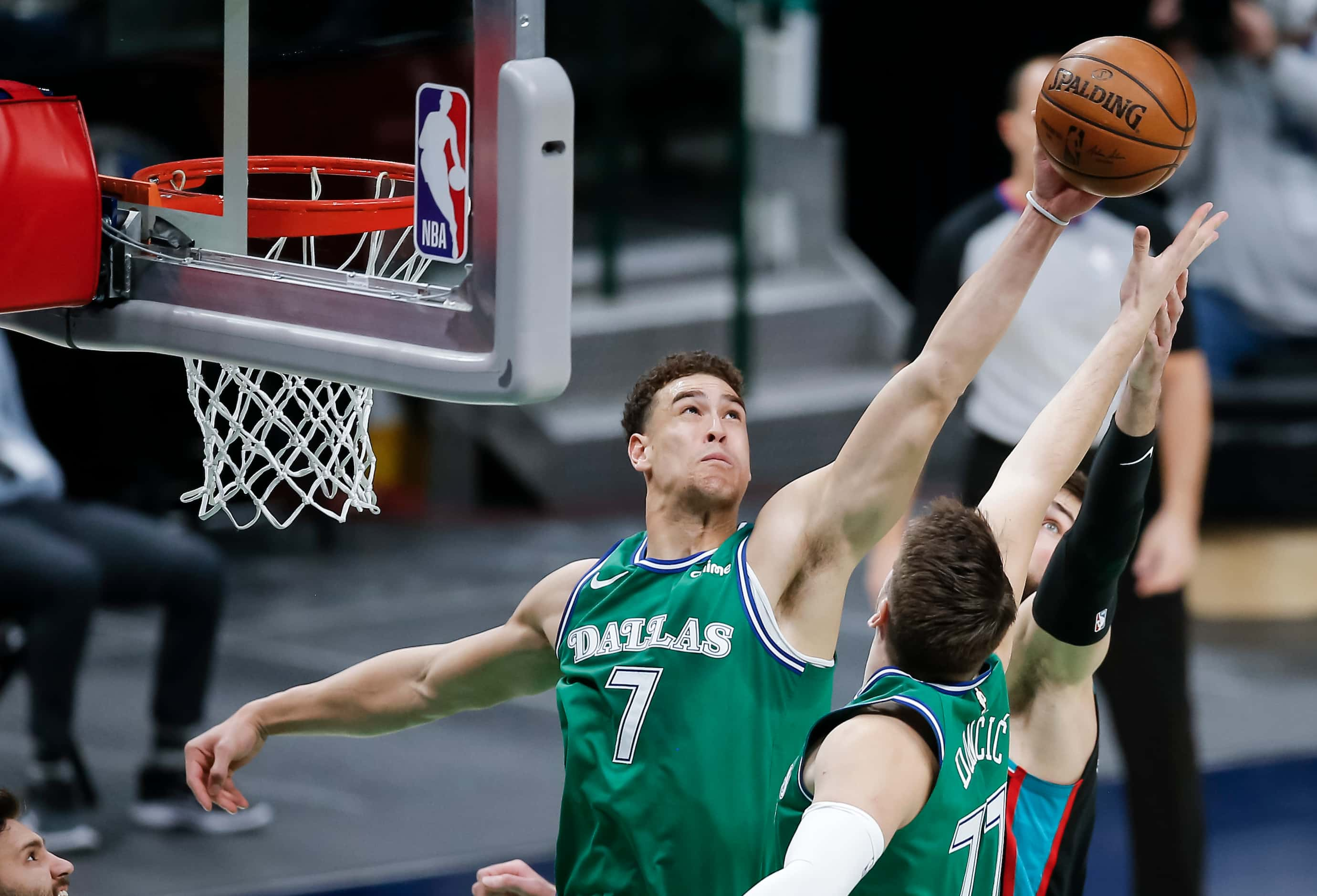 Dallas Mavericks forward Dwight Powell (7) and guard Luka Doncic (77) battle for a rebound...