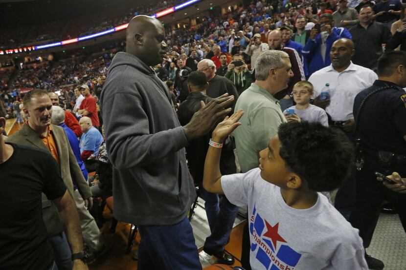 Shaquille 0'Neal, slaps hands with ballboy Michael Robertson, 10,  after he and the 1989 San...