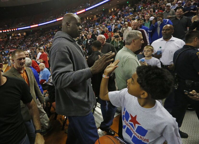 Shaquille 0'Neal, slaps hands with ballboy Michael Robertson, 10,  after he and the 1989 San...