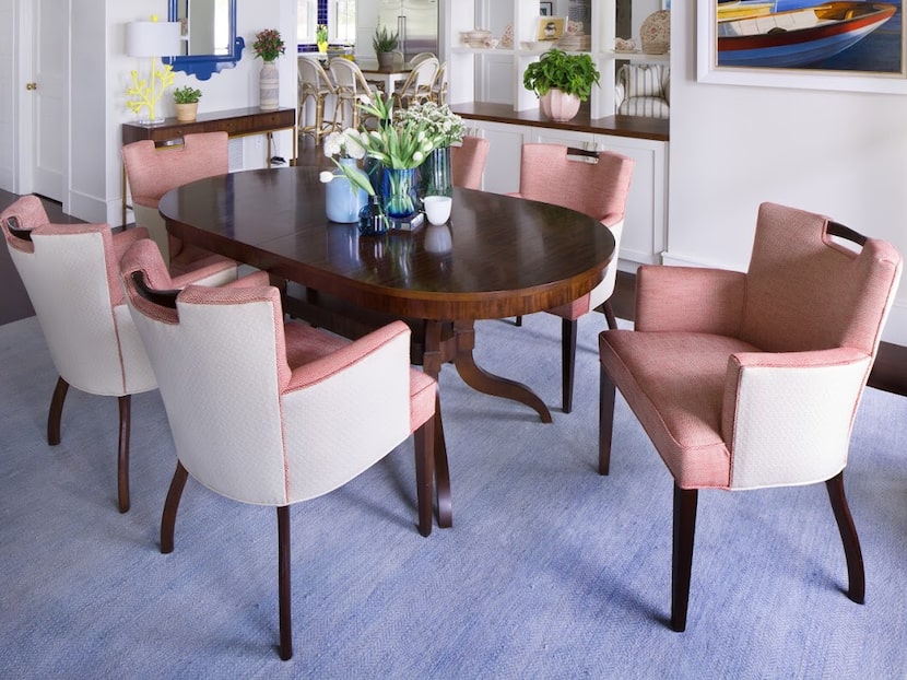 Dining room with pink upholstered chairs and a blue wool rug