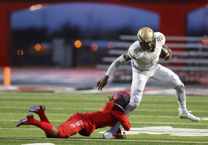 DeSoto's Tristen Wallace (5) breaks away from the grasp of Cedar Hill's Jameel Moore (5)...