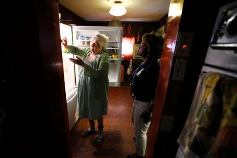 
Caseworker Valencia Hooper takes stock of Minnie Nobel’s refrigerator during a house call...
