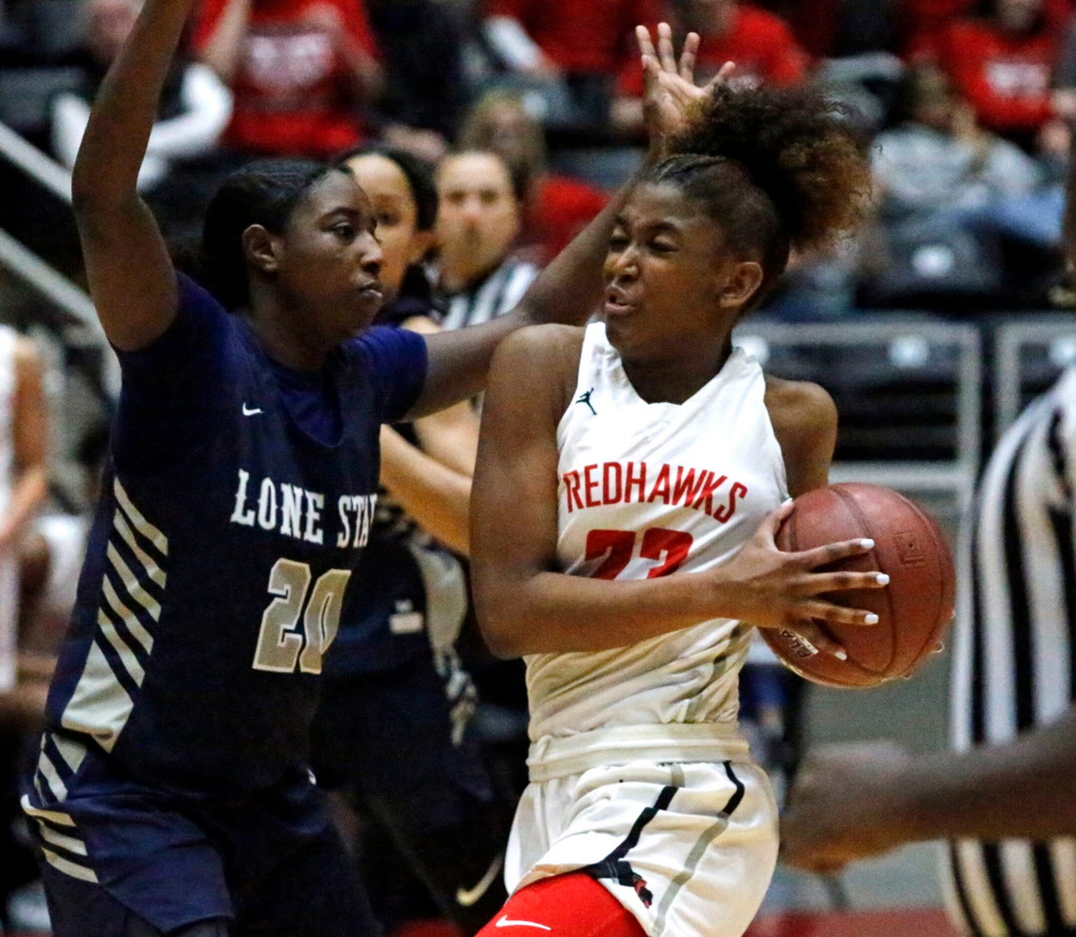 Liberty High School guard Randi Thompson (23) drives to the basket while defended by Lone...