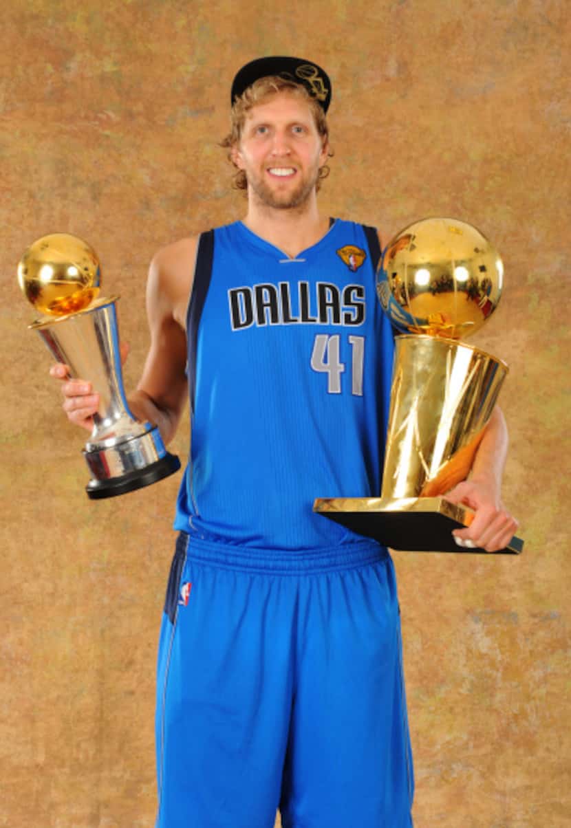 Dirk Nowitzki poses with the NBA championship trophy in his left arm and the NBA Finals MVP...