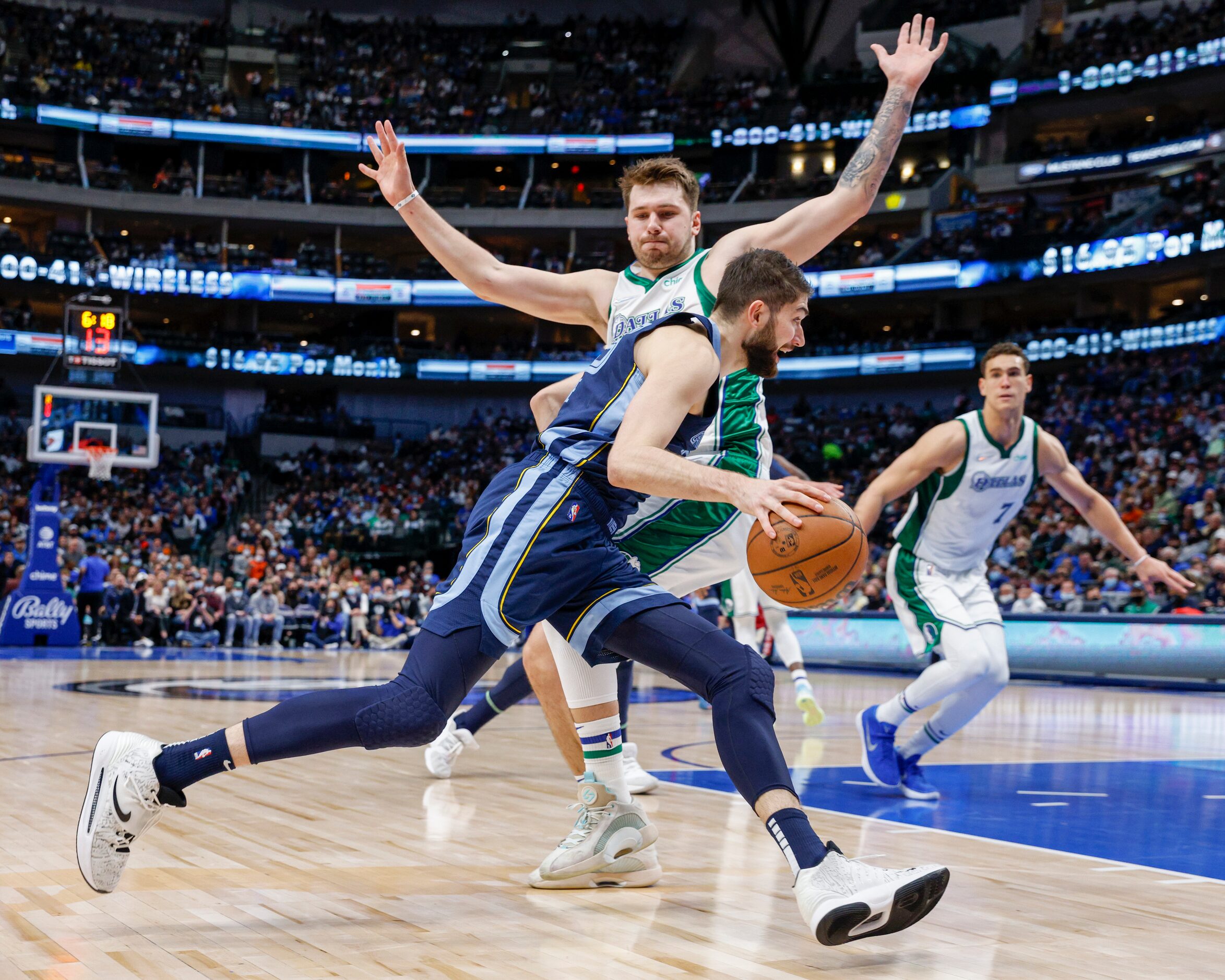 Dallas Mavericks guard Luka Doncic (77) defends against a driving Memphis Grizzlies forward...