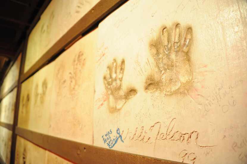 Celebrity artists, such as Willie Nelson, are invited to press their hands in cement and...