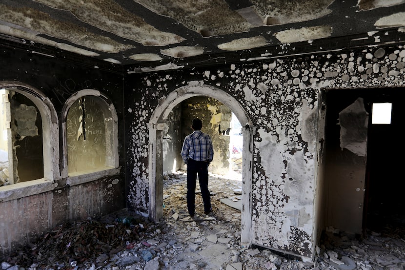 A former policeman in December 2019 walked through an abandoned home that was torched by the...