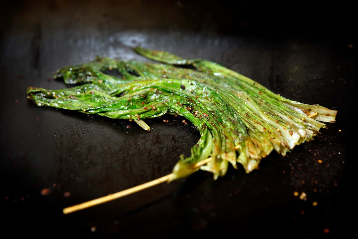 Skwered A-choy (Chinese greens) on a grill at FatNi BBQ (Tom Fox/Staff Photographer)