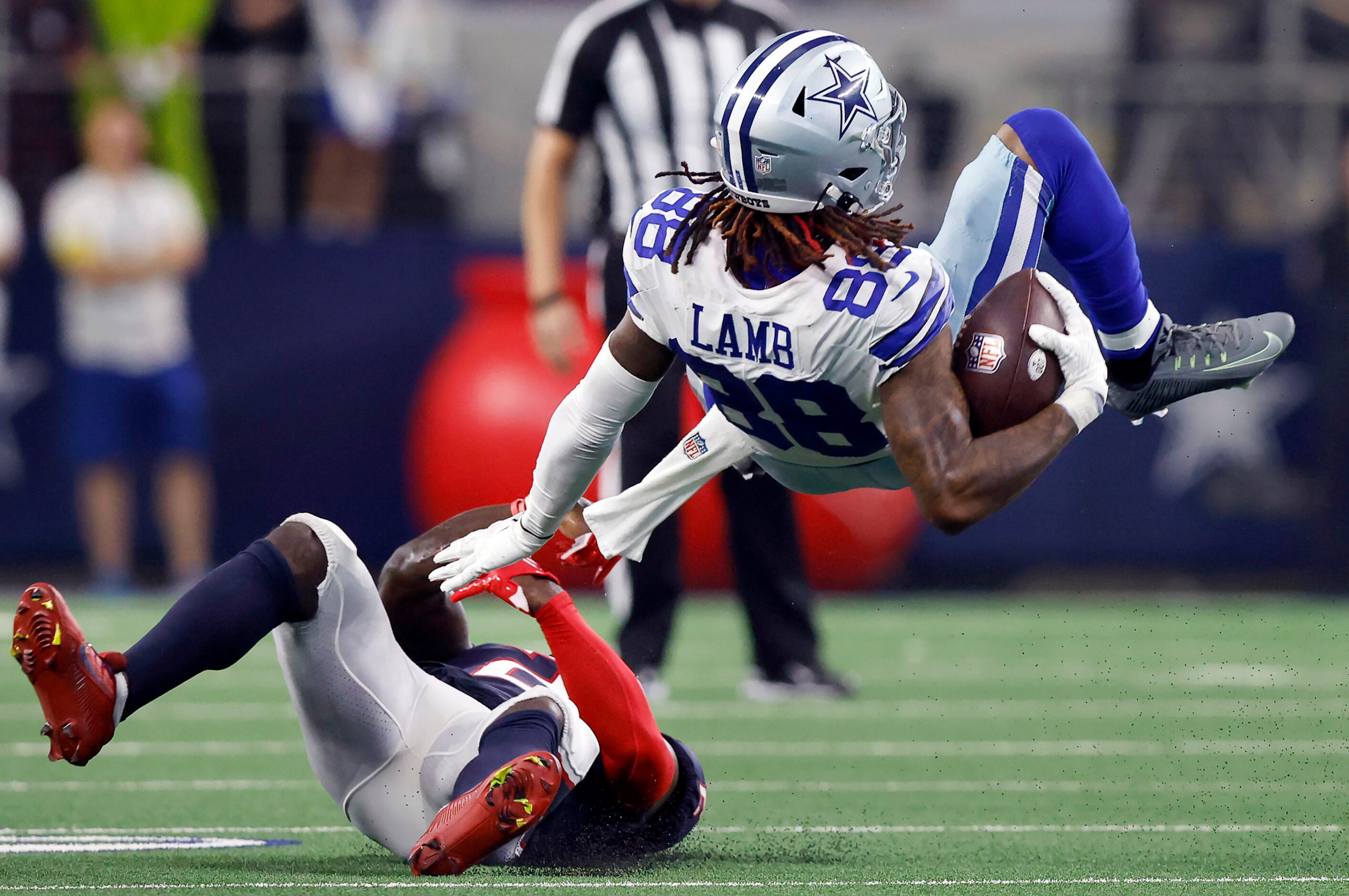 Dallas Cowboys wide receiver CeeDee Lamb (88) is flipped over by Houston Texans cornerback...