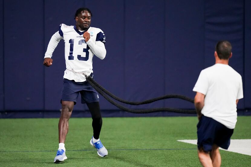 Dallas Cowboys wide receiver Michael Gallup works with a resistance band during the OTA...
