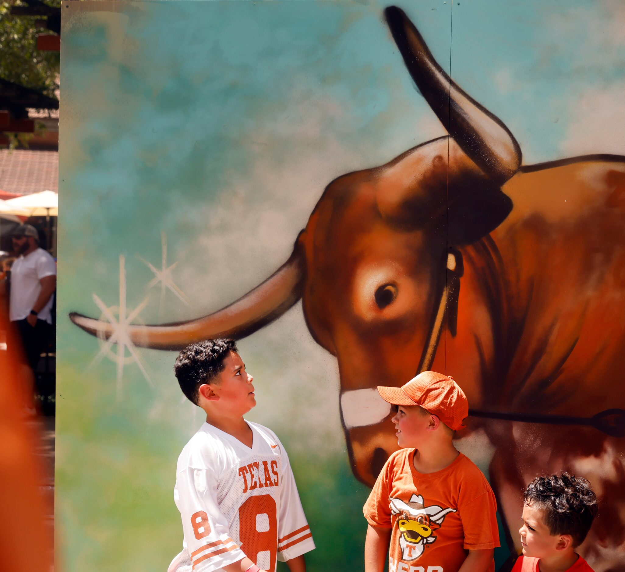 A young fan eye's a freshly spray painted image of the Texas Longhorns mascot Bevo as they...