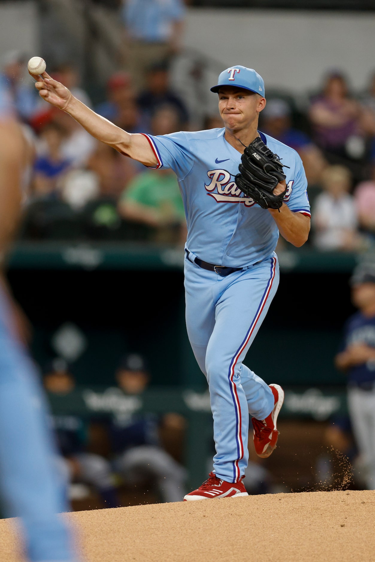 Texas Rangers starting pitcher Glenn Otto (49) throws to first base to hold the runner...