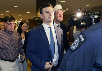 Former Cleveland Browns quarterback Johnny Manziel walks with his lawyer Jim Darnell, right,...