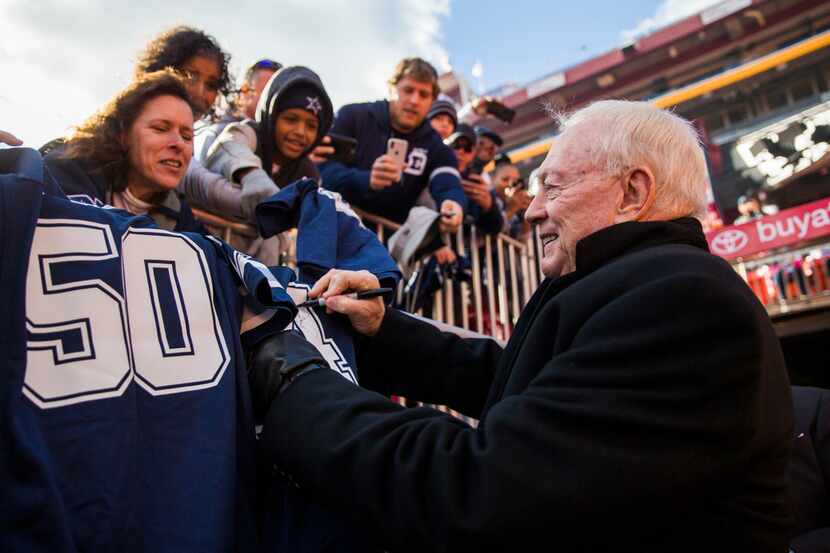 Cowboys owner Jerry Jones signs autographs for fans before a game against the Washington...