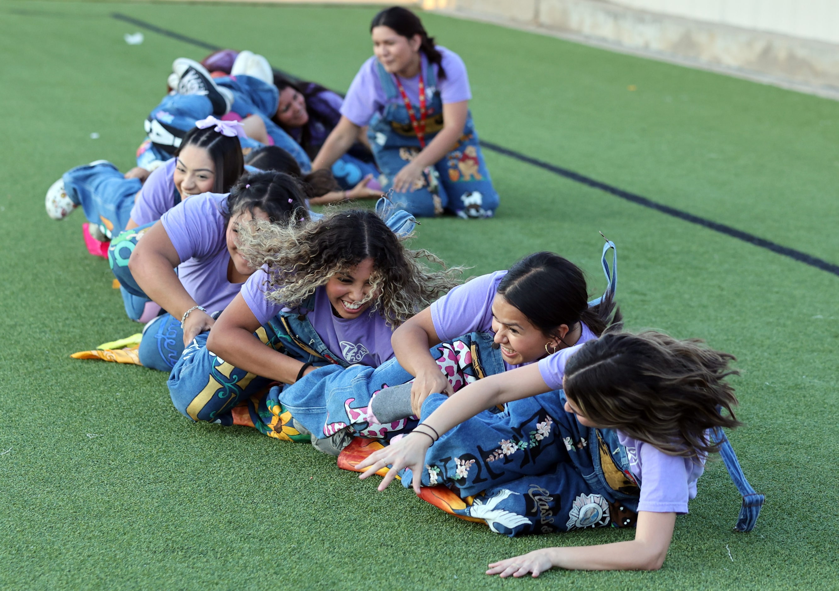 The Irving high sideline spirit crew rolls over in unison before the start of the first half...