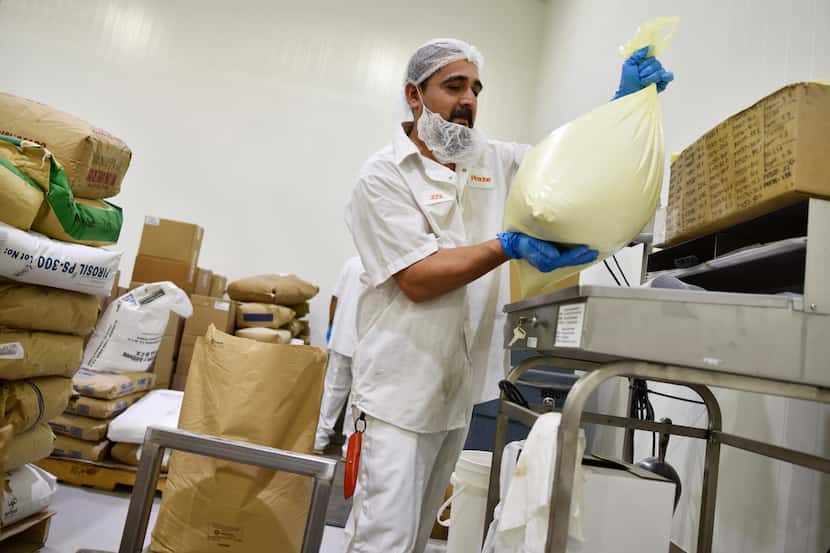 Weigh out operator Jose Martinez moves a bag of starch after weighing it on a scale inside...