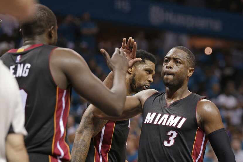 FILE - In this April 29, 2016, file photo, Miami Heat's Dwyane Wade (3) gives a high-five to...