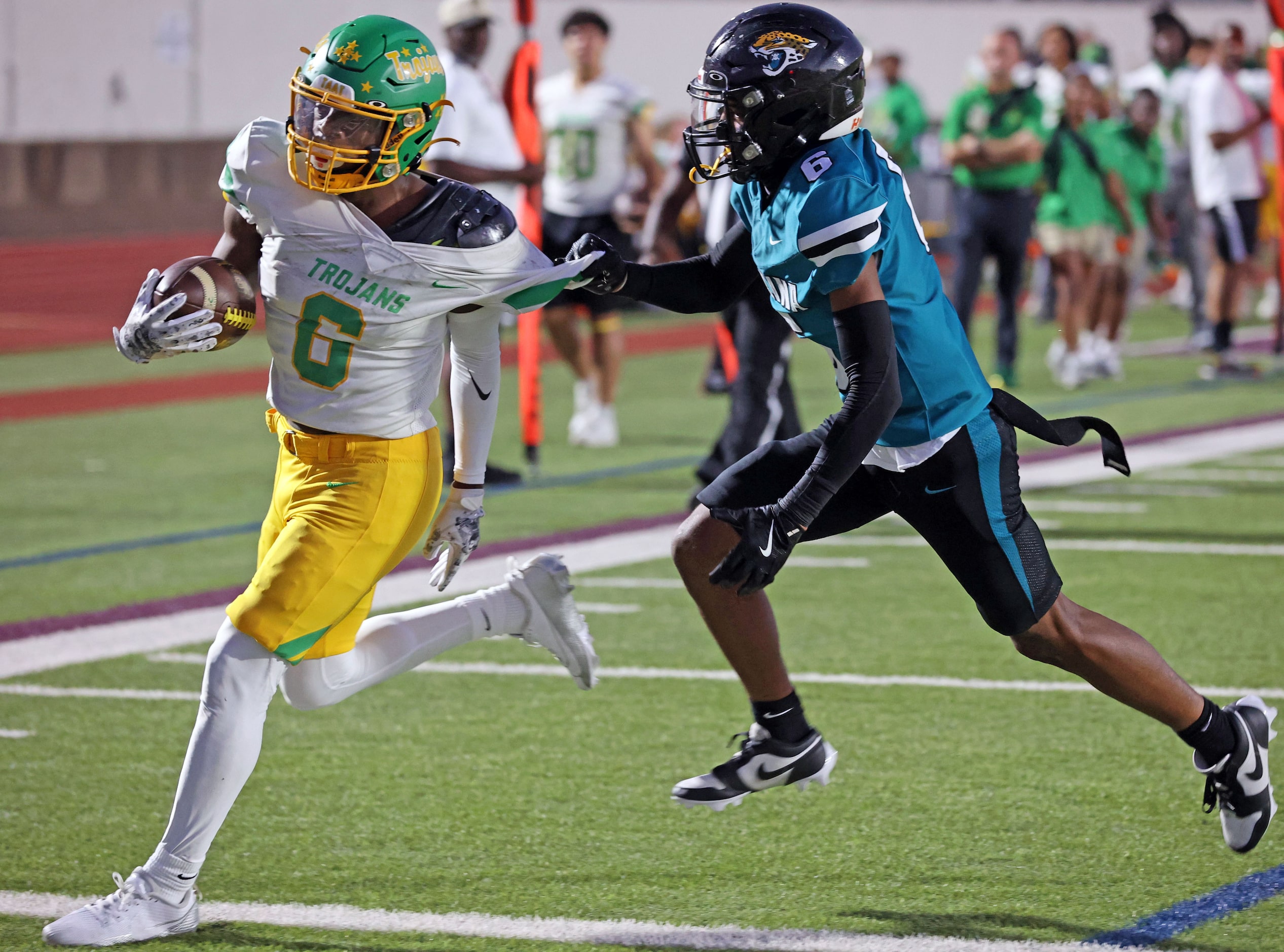 Carrollton Newman Smith high RB Allijah Harrison (6), loses part of his jersey, but skirts...