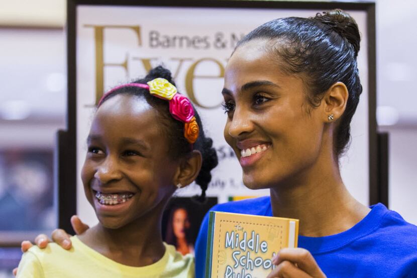 Dallas Wings star Skylar Diggins (right) poses for a photo with Carisyn Anderson, 9, during...