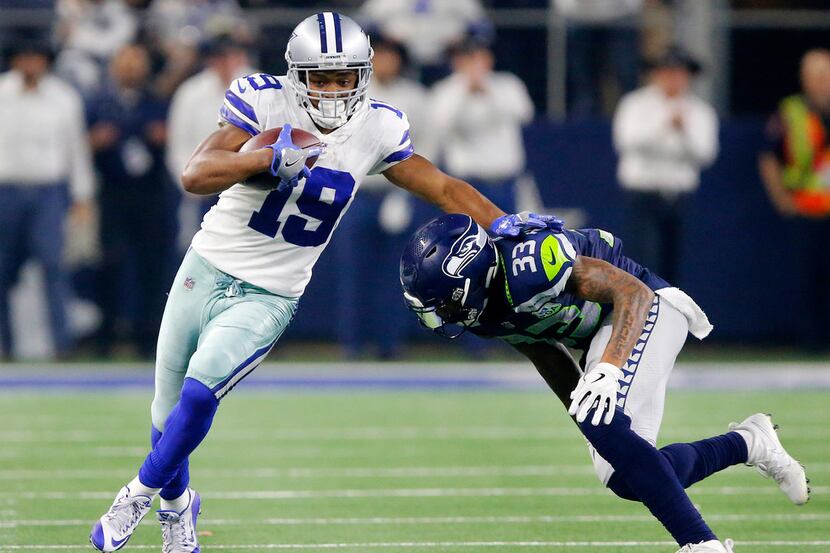 Dallas Cowboys wide receiver Amari Cooper (19) tries to avoid the tackle by Seattle Seahawks...
