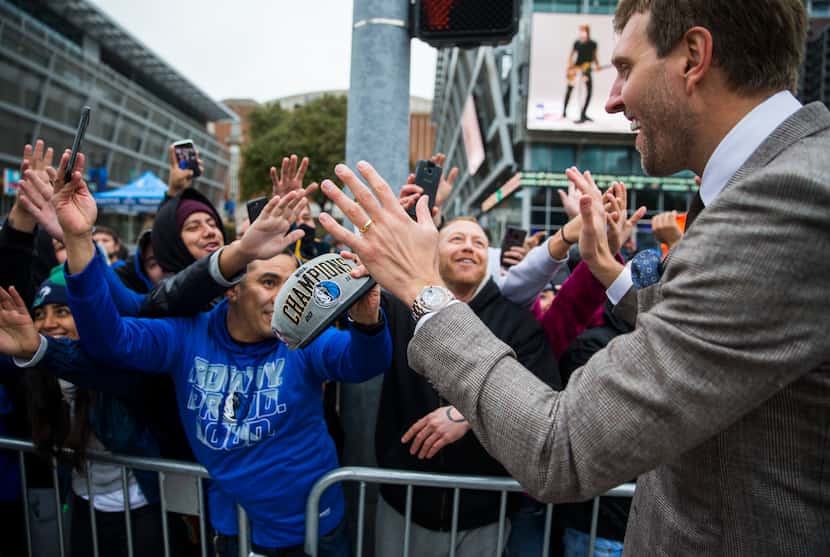Retired Dallas Mavericks player Dirk Nowitzki greets fans after unveiling a street sign with...
