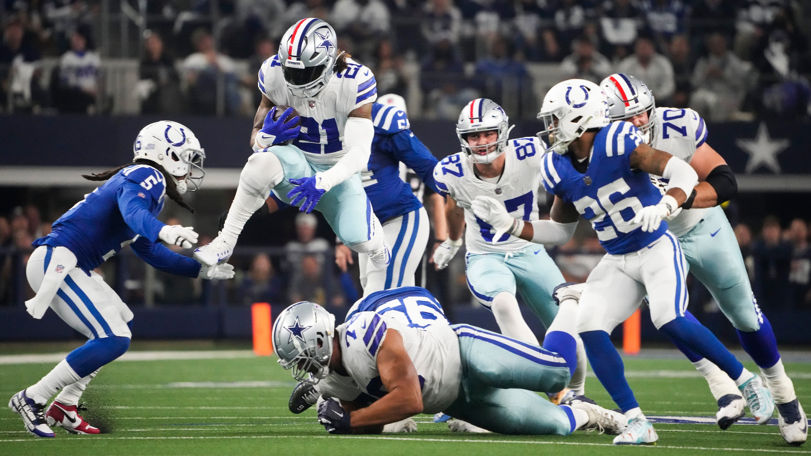 Dallas Cowboys running back Ezekiel Elliott (21) leaps over offensive tackle Terence Steele...