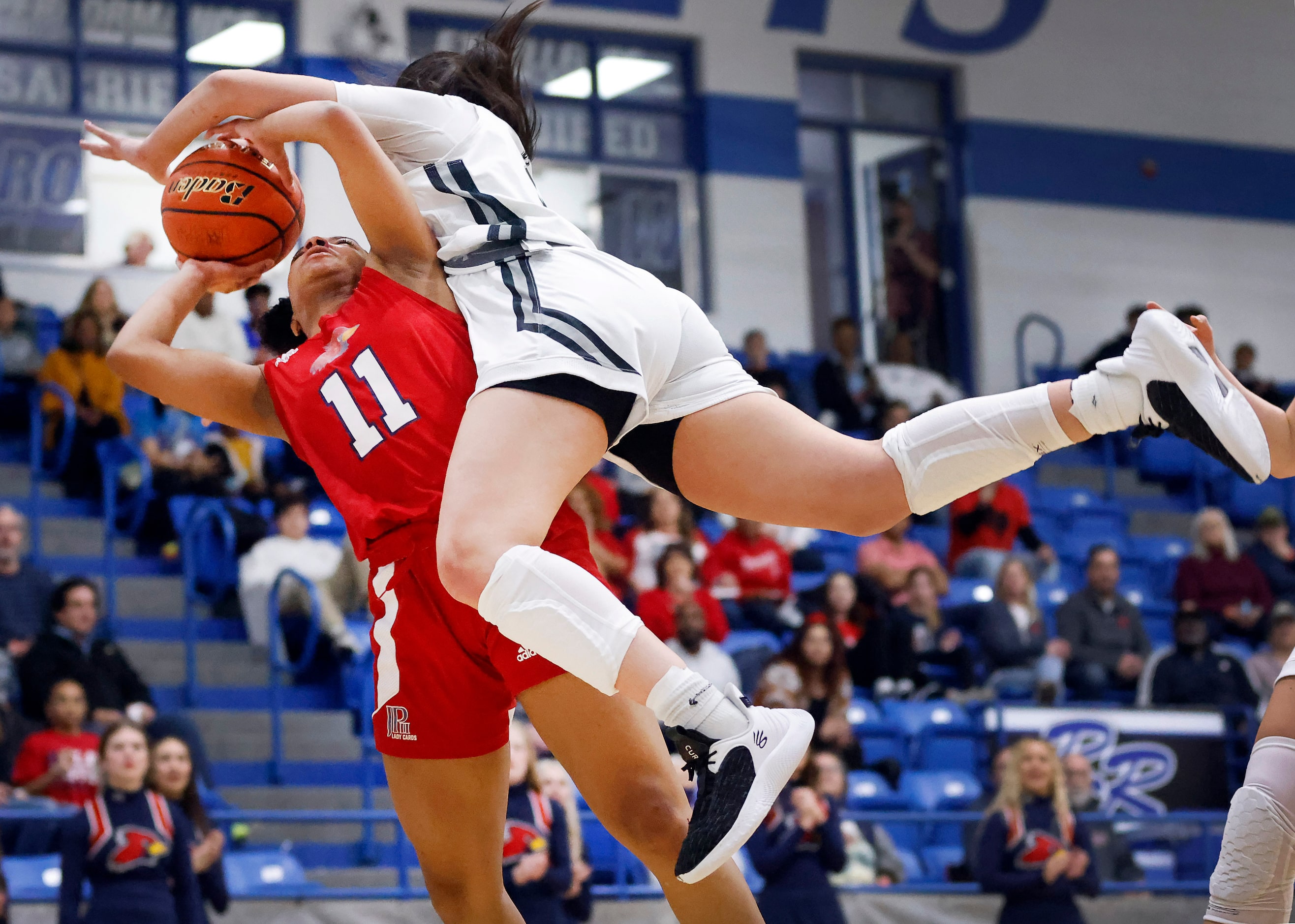 John Paul II guard Lydia Cook-Wiggins (11) is fouled hard by Bishop Lynch guard Natalie...