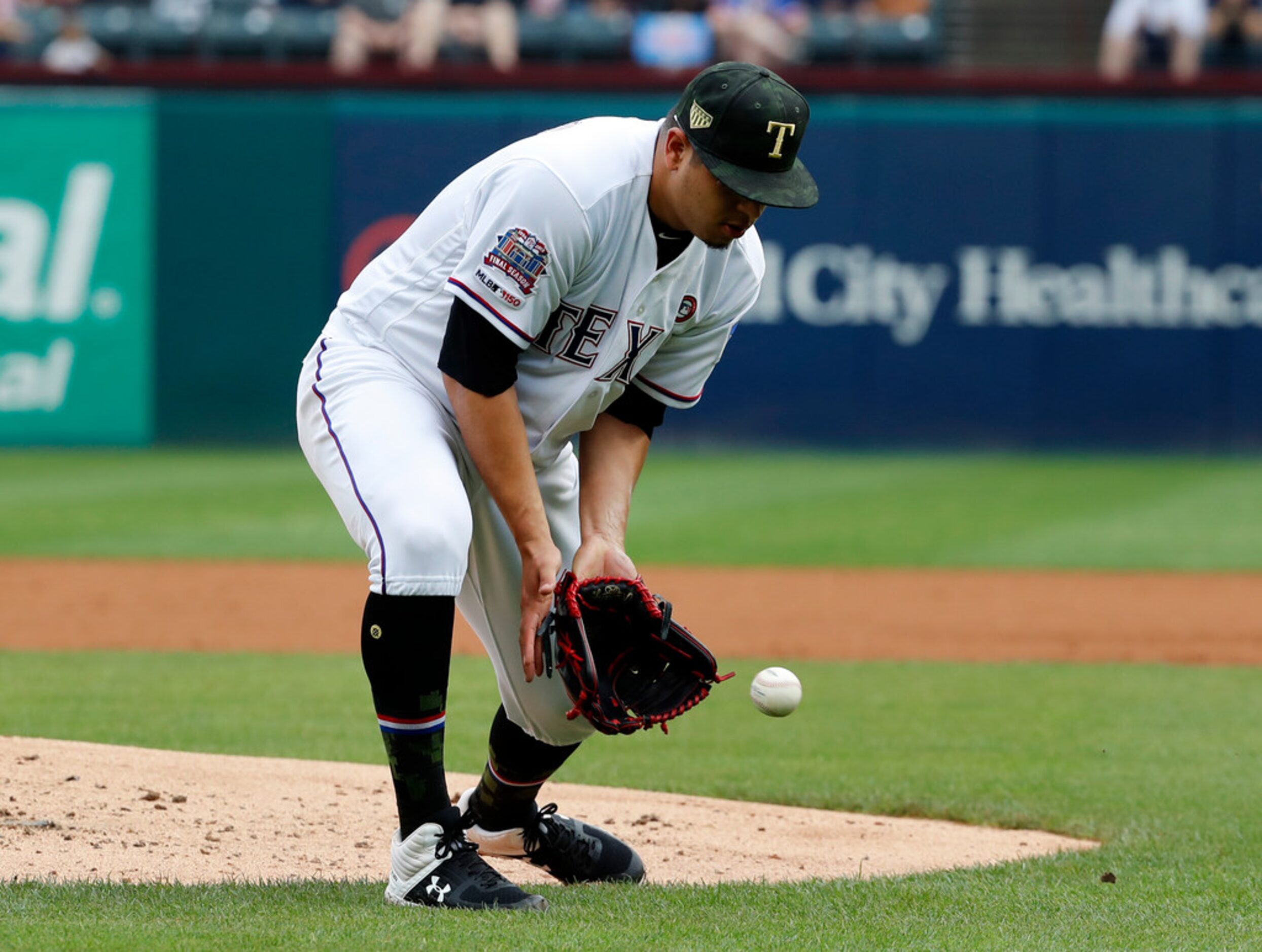 Texas Rangers relief pitcher Ariel Jurado reaches down to field a ground out by St. Louis...