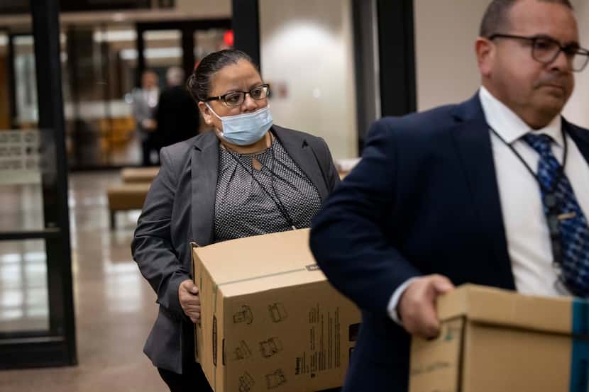 Dallas Police detectives Christine Ramirez (left) and Jose Ortiz Vives carry in boxes of...