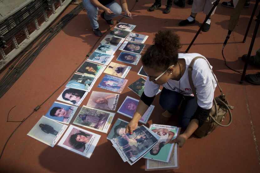 Una mujer coloca fotos de migrantes centroamericanos durante una marca de madres que buscan...
