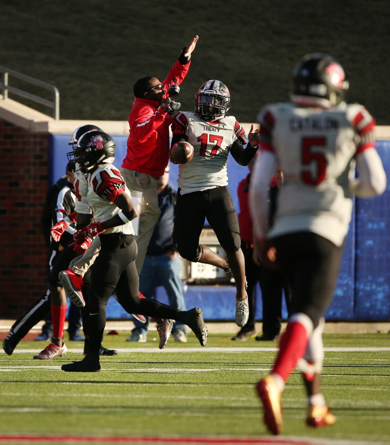 Mansfield Legacy linebacker Trey Wormley (17) celebrates with coaching staff after a play in...