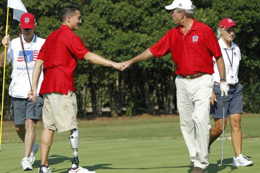 George W. Bush fist bumped with Jay Fain during tournament practice Sunday. The George W....